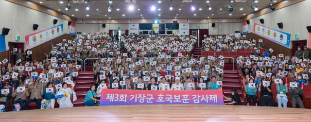 제3회 기장군 호국보훈 감사제에 참석한 보훈대상자와 군민들이 태극기를 들고 기념촬영을 하고 있다. [사진=기장군]