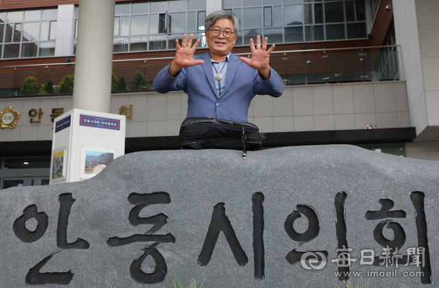 안동시의회 앞에 선 전국 최초 10선 이재갑 의원이 양손 손가락 열 개를 활짝 펼쳐 보이며 환하게 웃고 있다. 1991년 지방의회 출범 이후 단 한 번도 정당 배지를 달지 않은 채 열 번 연속 당선됐다. 정운철 기자 woon@imaeil.com