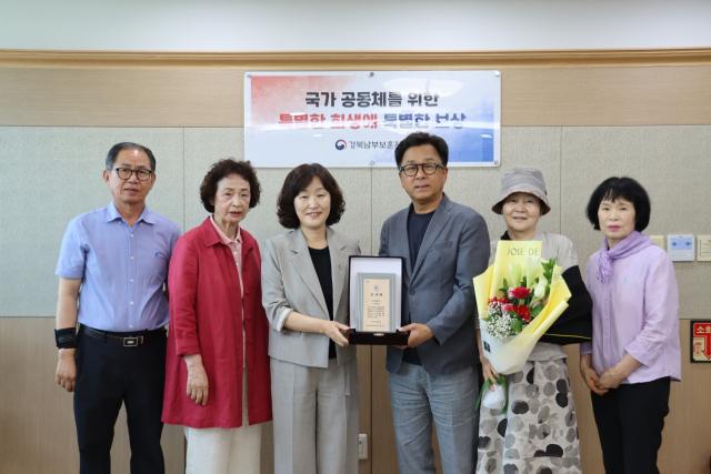 한마음봉사단 김정석 단장(오른쪽 세번째)과 단원들이 지난 17년 동안 국가보훈가족들의 주거환경 개선사업을 통해 복지증진에 기여한 공로로 국가보훈부장관 감사패를 배태미 경북남부보훈지청장(〃네번쨰)으로부터 전달받고 기념사진을 촬영하고 있다, 한마음봉사단 제공