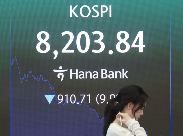 코스피가 10% 가까이 급락해 8,200선을 간신히 지키며 마감한 23일 서울 중구 하나은행 딜링룸에서 직원이 업무를 보고 있다. 이날 코스피는 전 거래일 대비 910.71포인트(9.99%) 내린 8,203.84로 거래를 마쳤다. 연합뉴스
