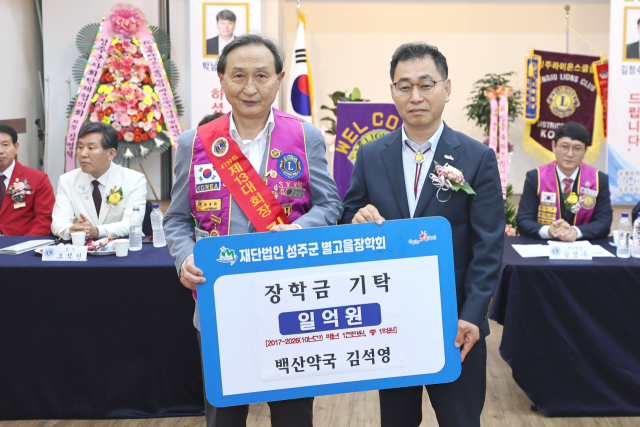 성주군 백산약국 김석영 대표(왼쪽)가 허윤홍 성주부군수에게 별고을 장학금을 전달하고 있다. 성주군 제공