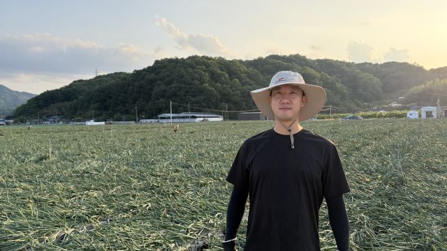 이경하 씨가 양파밭 앞에 서 있다. 본인 제공