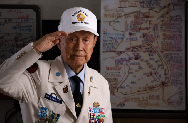 6·25전쟁 76주년을 맞은 25일, 6·25참전유공자회 대구지부 남구지회에서 만난 류영봉 참전용사가 전쟁 당시 격전지를 표시해 직접 만든 지도 앞에서 그날의 기억을 되새기며 경례하고 있다. 김영진 기자 kyjmaeil@imaeil.com