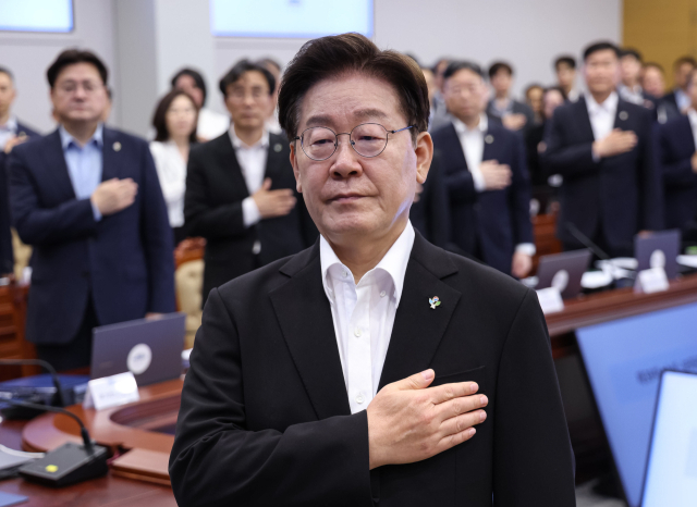 이재명 대통령이 25일 청와대에서 열린 수석보좌관회의에서 국기에 경례하고 있다. 연합뉴스