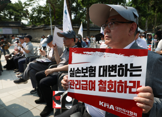 대한의사협회가 28일 서울 중구 대한문 앞에서 대한정형외과의사회, 대한신경외과의사회, 대한마취통증의학과의사회, 대한재활의학과의사회 등과 함께 연 도수치료 관리급여 전환 반대 궐기대회에서 참가자들이 손팻말을 들고 있다. 연합뉴스
