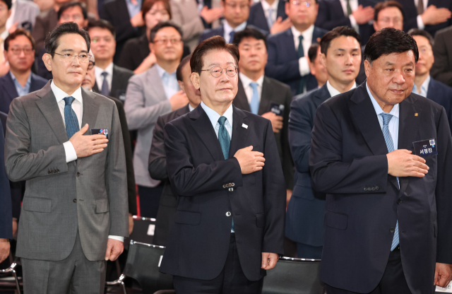 이재명 대통령이 2일 충남 아산시에서 열린 충청권 첨단산업 발전비전 국민보고회에서 국민의례를 하고 있다. 왼쪽부터 이재용 삼성전자 회장, 이재명 대통령, 서정진 셀트리온 회장. 연합뉴스