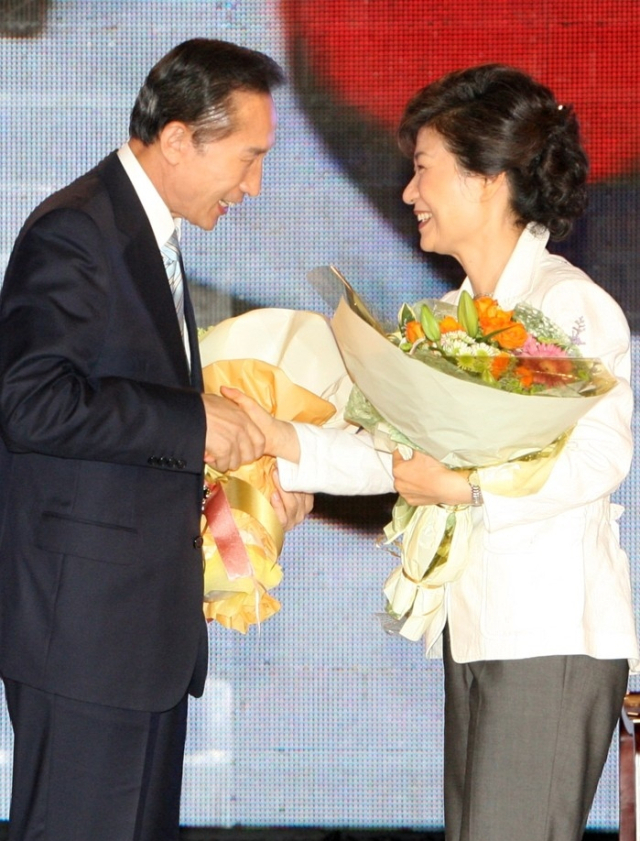 2007년 8월 20일 서울 올림픽공원 체조경기장에서 열린 한나라당 전당대회에서 17대 대선 후보로 확정된 이명박 전 서울시장(왼쪽)이 박근혜 전 한나라당 대표로부터 축하를 받으며 악수를 나누고 있다. 연합뉴스