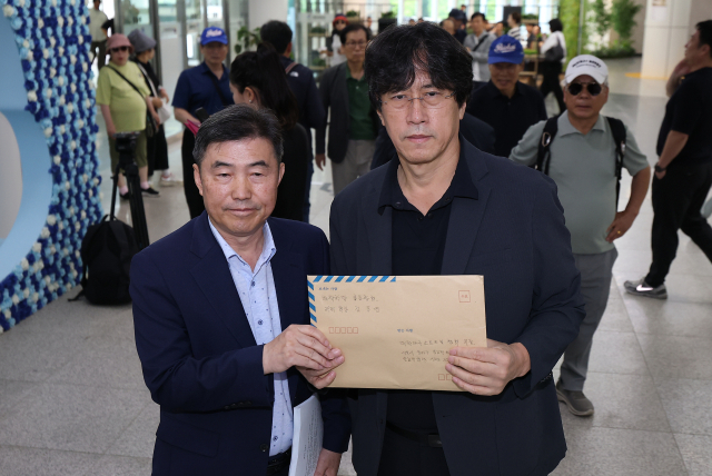 김동연 배재학당총동창회 39대 회장(오른쪽)이 3일 대한야구소프트볼협회가 위치한 서울 송파구 올림픽회관에서 스타벅스 응원 논란과 관련해 배재고 학생들의 선처를 바라는 탄원서를 제출하기 전 사진을 촬영하고 있다. 연합뉴스