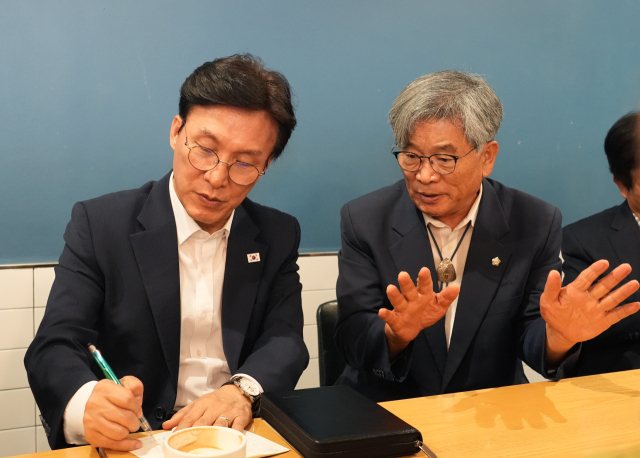 김민석 더불어민주당 당대표 후보가 19일 이재갑 안동시의회 의장(오른쪽)을 만나 연달아 발생한 각종 재난 상황으로 피폐해진 지역의 상황에 대해 설명을 듣고 있다. 안동시의회 제공