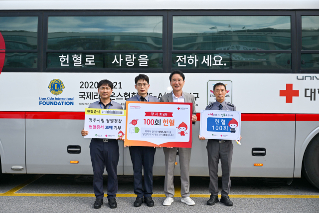 영주시청 청원경찰 장지호(왼쪽에서 두번째) 씨가 100번째 헌혈증서를 들고 기념사진을 촬영했다. 영주시 제공