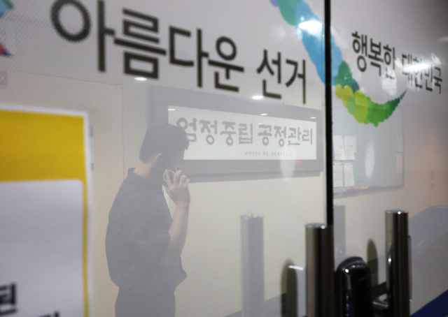 23일 합동수사본부가 압수수색 중인 서울 송파구선거관리위원회 복도에서 한 관계자가 전화 통화를 하고 있다. 투표용지 부족 사태 진상 규명을 위한 검경 합동수사본부는 이날 오전부터 경기도 과천시 중앙선관위와 송파구·강남구·서초구 선관위 등을 압수수색 중이라고 밝혔다. 연합뉴스