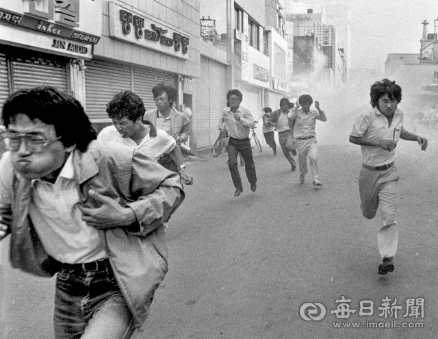 1987년 6월 16일 대구 6개 대학 연합 시위 2일째 중앙로 중앙파출소 부근에서 경찰이 쏜 최루탄에 골목으로 흩어지는 대학생들. © 매일신문