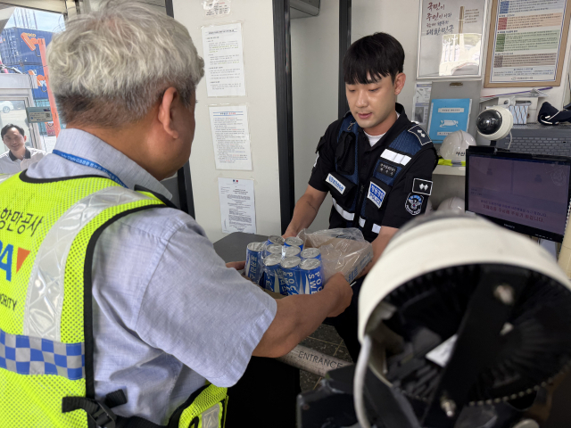 부산항만공사 직원이 부산항 현장 근로자에게 이온음료를 전달하며 폭염 속 온열질환 예방과 안전수칙 준수를 당부하고 있다. [사진=부산항만공사]