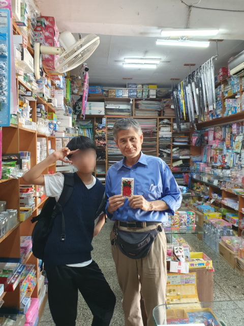 대구 만촌초 앞 대성문구사 주인 이긍호 씨가 단골 학생에게 카네이션을 받은 모습. 대성문구사 제공