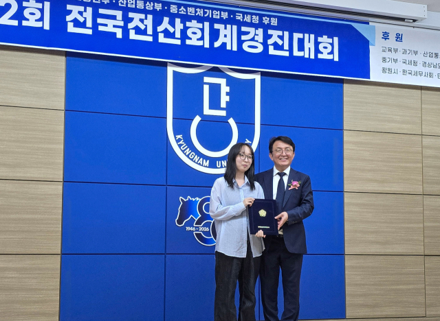 지난달 11일 경남대학교에서 열린 제32회 전국 전산세무회계 경진대회에서 중기부장관상을 받은 박세미 학생(왼쪽)이 대회 관계자와 포즈를 취하고 있다. 영진전문대 제공