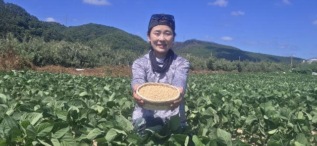 콩밭에서 수확한 콩을 들어보이고 있는 강민재 씨. 본인 제공