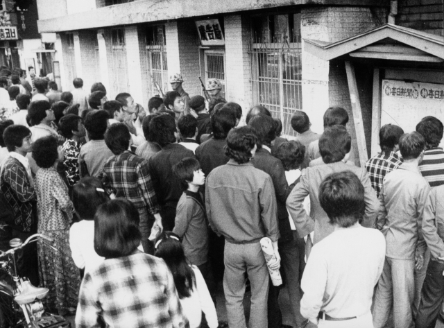 1979년 고 박정희 대통령 시해 사건은 김재규의 계획된 범행이라는 특보에 시민들이 경악을 감추지 못하고 있다. 사진은 매일신문사 게시판 특보를 보고있는 시민들. 매일신문 DB.