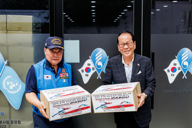 대한민국국가유공자봉사회의 정정호 이사장(오른쪽)과 정덕주 사무총장(왼쪽)이 2026대구세계마스터즈육상대회 참가국 선수들에게 줄 기부물품을 상자에 포장해 들고 있다. 이화섭 기자
