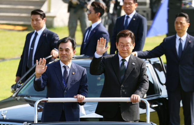 이재명 대통령이 지난해 10월 1일 열린 건군 77주년 국군의 날 기념행사에서 열병차량에 탑승해 손을 흔들고 있다. 왼쪽은 안규백 국방부 장관. 연합뉴스