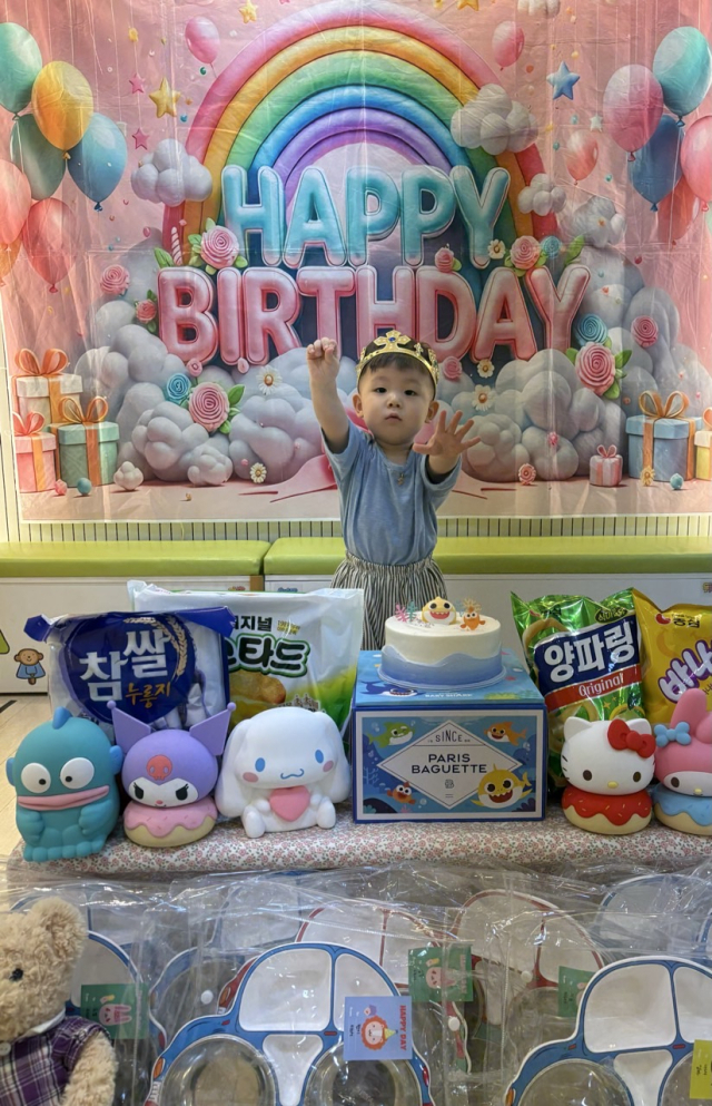 어린이집에서 열린 생일파티에서 생일을 맞은 아이가 친구들에게 나눠줄 구디백과 함께 기념사진을 찍고 있다. 최근 어린이집·유치원에서는 생일을 맞은 아이가 축하해 준 친구들에게 간식이나 장난감 등을 담은 구디백을 답례품으로 나눠주는 문화가 자리 잡고 있다. 독자 제공