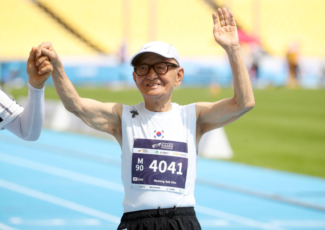 23일 대구스타디움에서 열린 2026 대구세계마스터즈육상경기대회(WMAC) M90 100m 경기에 출전한 국내 최고령 참가자 90세 김명락씨가 경기를 끝낸 뒤 응원하는 사람들에게 손을 흔들고 있다. 연합뉴스