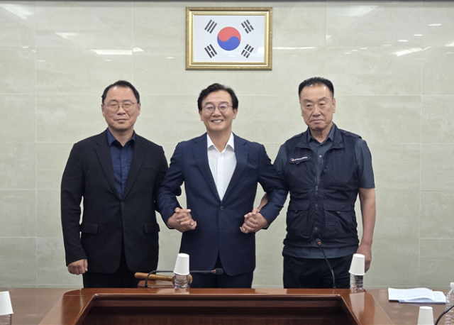 부산 시내버스 노사가 임금협상을 타결한 뒤 전재수 부산시장과 함께 손을 맞잡고 있다. [사진=부산시]