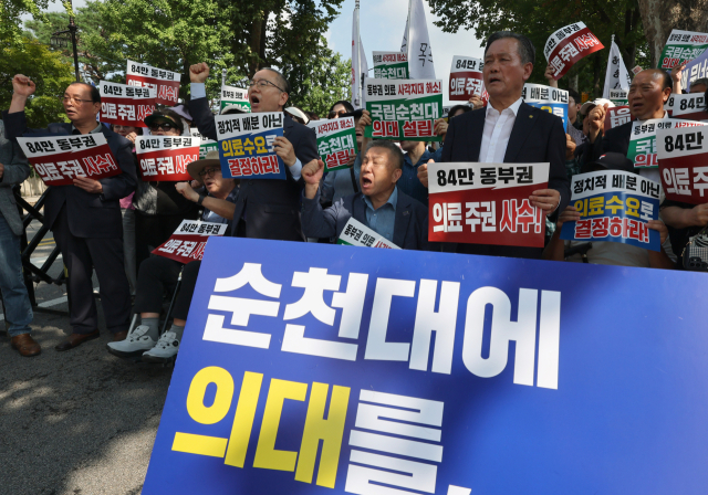 18일 서울 청와대 사랑채 앞에서 순천대 의대·대학병원 설립 전남광주동부권 범시민추진위원회가 개최한 궐기대회에 참가한 지역 주민들이 순천대에 의과대학과 대학병원을 함께 설립할 것을 촉구하는 구호를 외치고 있다. 연합뉴스