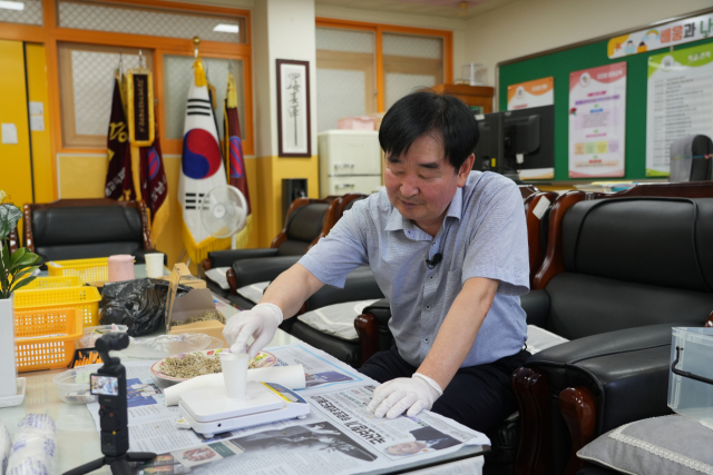 황석수 안동강남초등학교 교장이 아이들이 필사를 하고 먹을 수 있는 포상 선물로 국내산 멸치를 직접 구워 만든 간식을 소분하고 있다. 김영진 기자