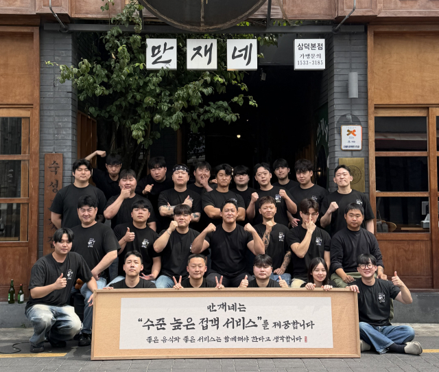 송민재 만재푸드 대표와 직원들이 대구 중구 종로 만재네 앞에서 기념촬영을 하고 있다. 송 대표는 오랫동안 함께한 직원들과 브랜드를 키우며 일부 직원은 회사 이사와 공동사업자로 성장했다.