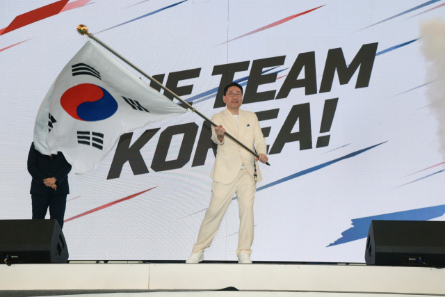 이상현 2026 아이치·나고야 아시안게임 선수단장이 3일 충북 진천선수촌에서 열린 결단식에서 유승민 대한체육회장으로부터 단기를 받아 흔들고 있다. 연합뉴스