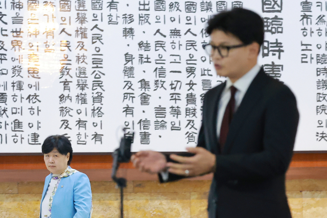 국회 법제사법위원장인 더불어민주당 서영교 의원이 9일 국회 로텐더홀에서 김승원 법무부 장관 후보자와 관련해 취재진 질문에 답하는 무소속 한동훈 의원을 보며 지나가고 있다. 연합뉴스
