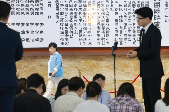 국회 법제사법위원장인 더불어민주당 서영교 의원이 9일 국회 로텐더홀에서 김승원 법무부 장관 후보자와 관련해 취재진 질문에 답하는 무소속 한동훈 의원을 보며 지나가고 있다. 연합뉴스