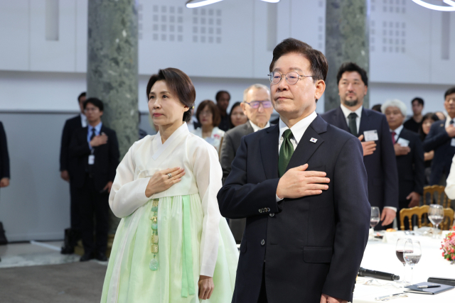 이재명 대통령과 김혜경 여사가 9일(현지시간) 프랑스 파리 한 호텔에서 열린 동포 오찬간담회에서 국기에 경례하고 있다. 연합뉴스