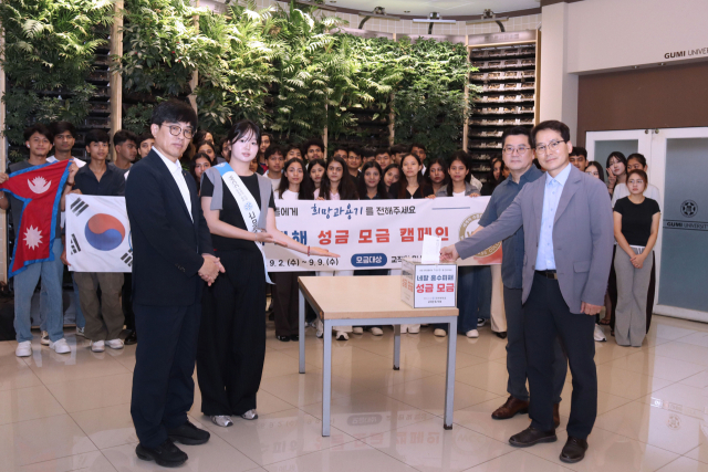 박홍순 스마트건설기계학부장 및 이창원 스마트경영과학과장이 성금을 넣고 있다. 구미대 제공