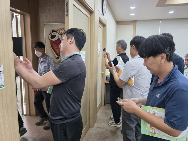 성주군 외국인 계절근로 고용주 교육 참가자들이 QR코드 촬영으로 교육 이수를 확인하고 있다. 이영욱 기자