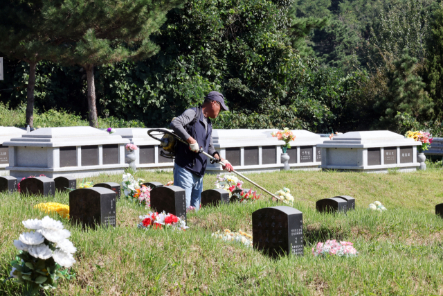 13일 오전 전남광주 북구 영락공원묘지에서 성묘객이 추석을 앞두고 조상의 묘 주변을 벌초하고 있다. 연합뉴스