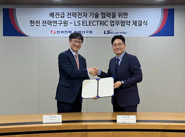 서장철 LS일렉트릭 전력CTO(상무)(오른쪽)와 김대한 한전 전력연구원장(왼쪽)이 체결식에서 기념촬영을 하는 모습 (사진= LS일렉트릭 제공)