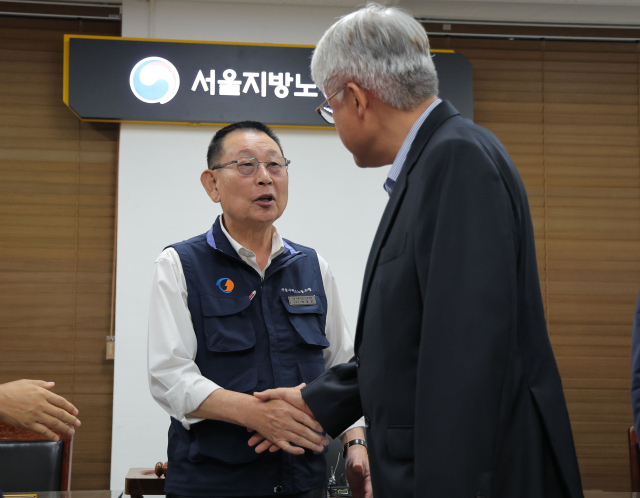 16일 서울 영등포구 서울지방노동위원회에서 열린 버스노조의 노동 쟁의 관련 분쟁에 대한 조정 회의에서 김정환 서울시버스운송조합 이사장과 박점곤 서울시버스노조 위원장이 조정안에 서명한 뒤 인사를 나누고 있다. 연합뉴스