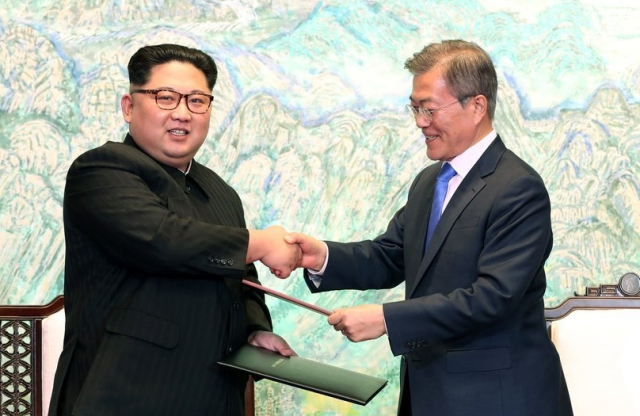 2018년 4월 27일 당시 문재인 대통령과 김정은 북한 국무위원장이 판문점 평화의 집에서 한반도의 평화와 번영, 통일을 위한 판문점 선언문에 서명한 뒤 교환하고 있다. 연합뉴스