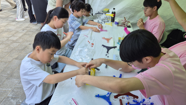 대구과학고 학생들이 실(장력재)과 막대(압축재)만으로 공중에 뜨는 텐세그리티 구조물 체험을 도와주고 있다. 대구시교육청 제공