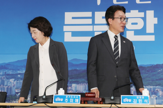 더불어민주당 김민석 대표가 21일 오전 경기도 의정부시 경기도북부청사에서 열린 제16차 경기 최고위원회의에서 추미애 경기도지사(왼쪽)와 악수를 나눈 뒤 자리에 앉고 있다. 연합뉴스