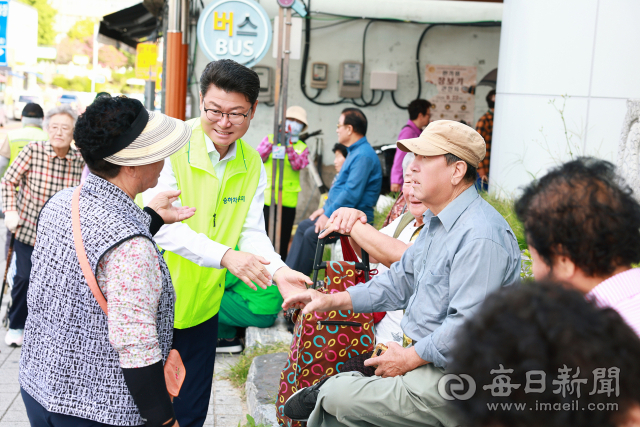 황이주 울진군수가 22일 울진읍 전통시장 앞 버스정류장에서 어르신들과 이야기를 나누고 있다. 울진군 제공