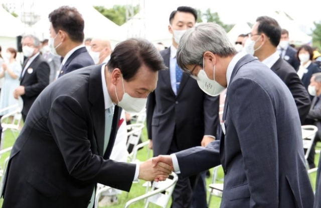 2022년 8월 15일 당시 윤석열 대통령(왼쪽)과 김명수 대법원장이 서울 용산 대통령실 청사 잔디마당에서 열린 77주년 광복절 경축식 종료 후 인사를 나누고 있다. 연합뉴스