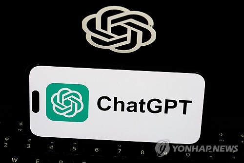 챗GPT 로고 앞에서 한 이용자가 스마트폰을 사용하고 있다. 연합뉴스