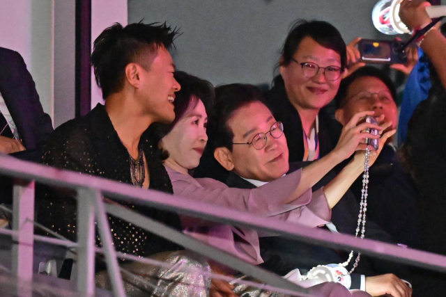 이재명 대통령과 김혜경 여사가 25일(현지시간) 멕시코시티 GNP 스타디움에서 열린 스트레이시티 콘서트에서 대중문화교류위원회 공동위원장인 박진영 JYP엔터테인먼트 대표 프로듀서와 기념촬영을 하고 있다. 연합뉴스