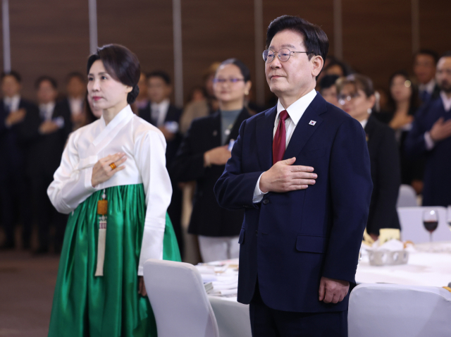 이재명 대통령과 김혜경 여사가 24일(현지시간) 멕시코 한 호텔에서 열린 동포 만찬간담회에서 국기에 경례하고 있다. 연합뉴스