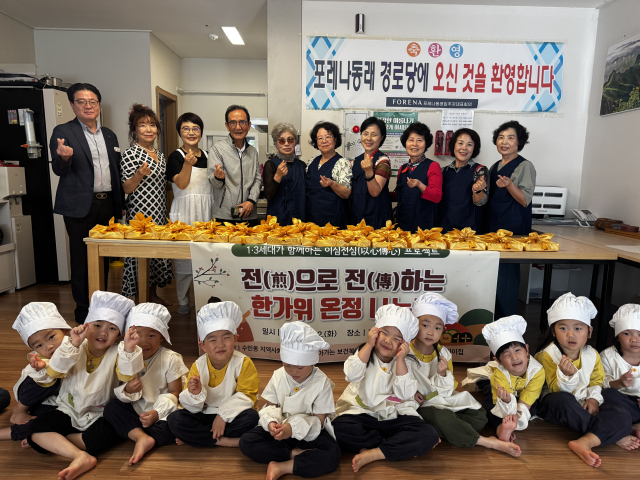 부산 동래구 포레나동래 경로당에서 추석 음식 나눔 행사에 참여한 어르신들과 어린이들이 기념촬영을 하고 있다. [사진=동래구]