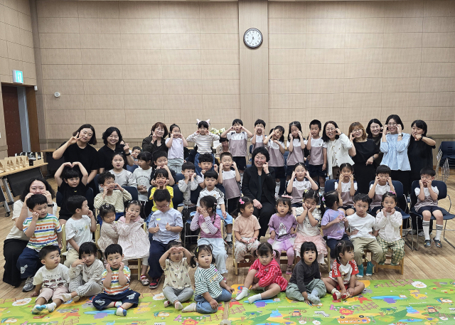 영양어린이집 원생과 교사들이 신상숙 원장(가운데)의 퇴임식에 참석해 하트 모양을 만들며 기념 촬영을 하고 있다. 영양군 제공
