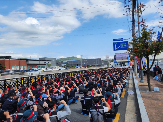 29일 경북 구미시 LS전선 구미사업장 앞 도로에서 붉은 머리띠와 조끼를 착용한 노조원 1천여 명이 도로에 도열해 구호를 외치며 총력투쟁 결의대회를 진행하고 있다. 조규덕기자