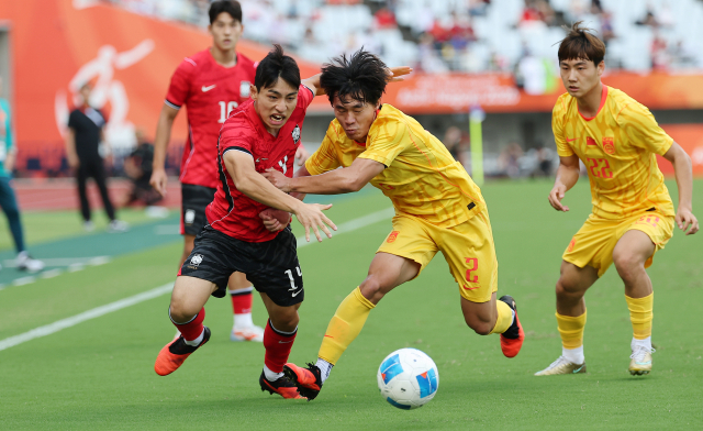 한국의 이현주가 30일 일본 오사카 나가이 스타디움에서 열린 2026 아이치·나고야 아시안게임 남자 축구 준결승 도중 먼저 공을 확보하기 위해 중국의 후허타오와 몸싸움을 벌이고 있다. 연합뉴스